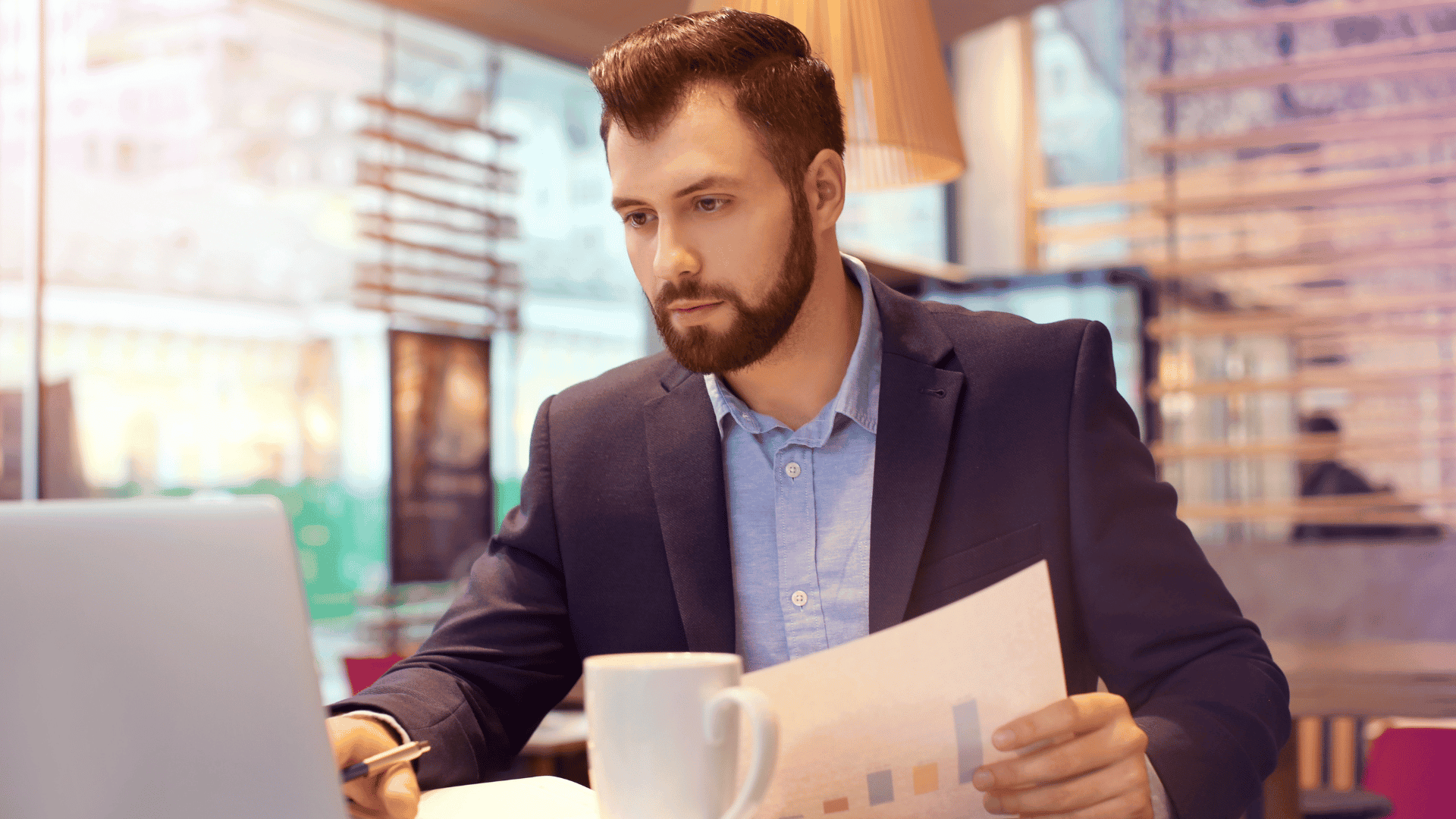 A man looking at a laptop with a business model diagram on the screen